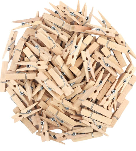 Collection of wooden clothespins with a hand holding one, on a white background | Cocktail Ceremony