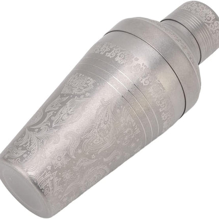 Decorative metal object with intricate engravings on a white background