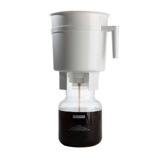 White coffee maker with glass carafe on a gray background