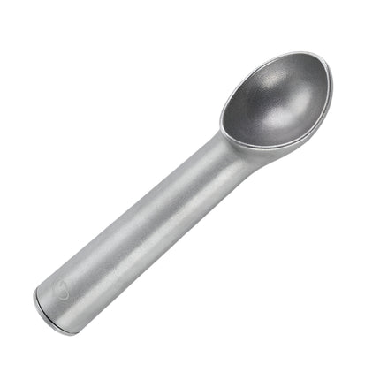 Metallic ice cream scoop on a light gray background