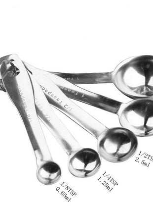 Set of stainless steel measuring spoons with measurements on a white background