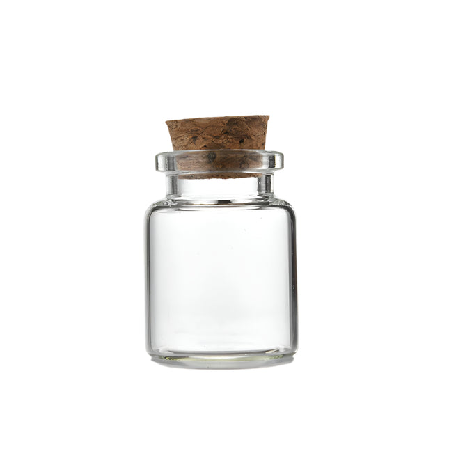 Small clear glass jar with cork lid and measurements on a white background
