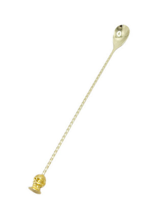 A bar spoon with a madeleine at the end, with a skull-shaped madeleine on a stainless steel spoon, attached to a ring.