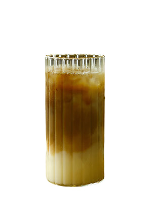 Glass of iced coffee on a wooden tray with a blurred background