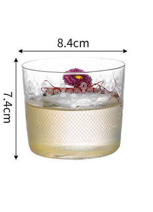 Glass tumbler with floral design and measurements on a white background