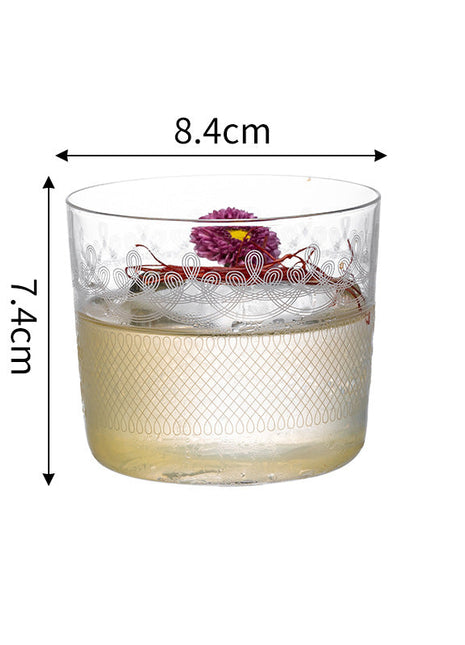 Glass tumbler with floral design and measurements on a white background